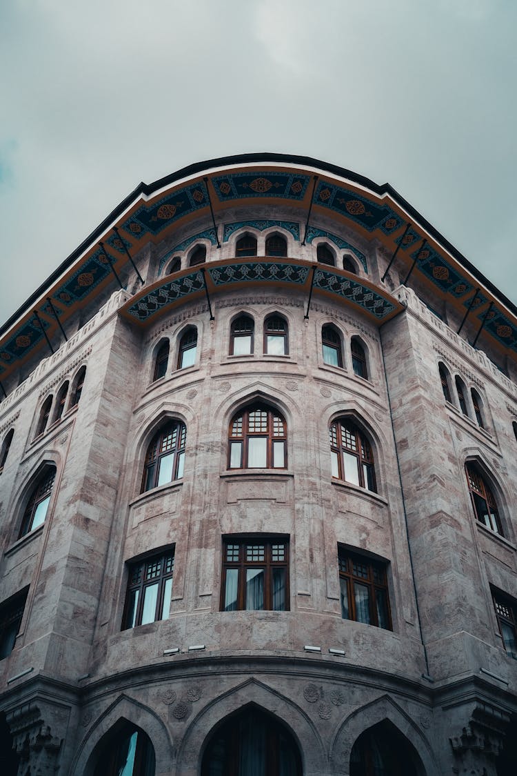 A Curved Corner Of A Building With Glass Windows