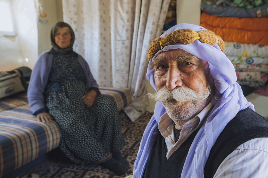 Middle Eastern older couple sitting together indoors