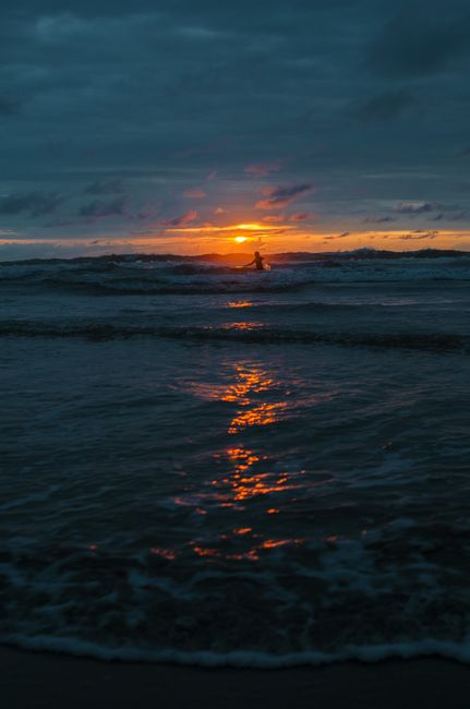 Serene sunset scene highlighting ocean waves and vibrant sky reflection.