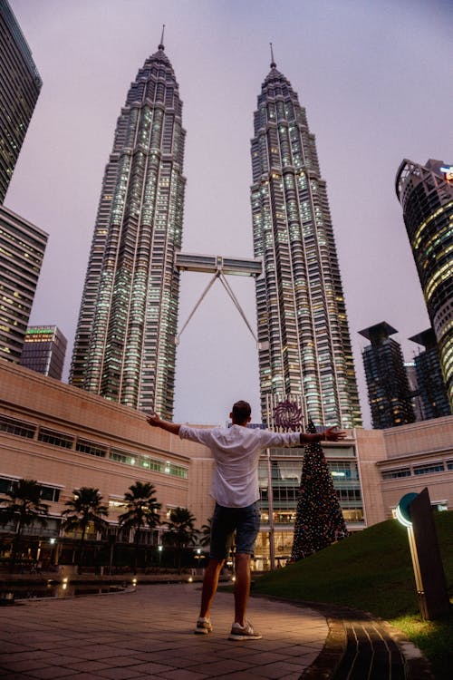 A Person Standing Near Petronas Twin Towers in Kuala Lumpur, Malaysia