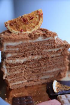 Close-up of a layered honey cake with dried orange slice topping, showcasing its texture.