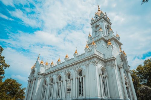 Free Low angle view of a historic church's intricate architecture under a blue sky. Stock Photo