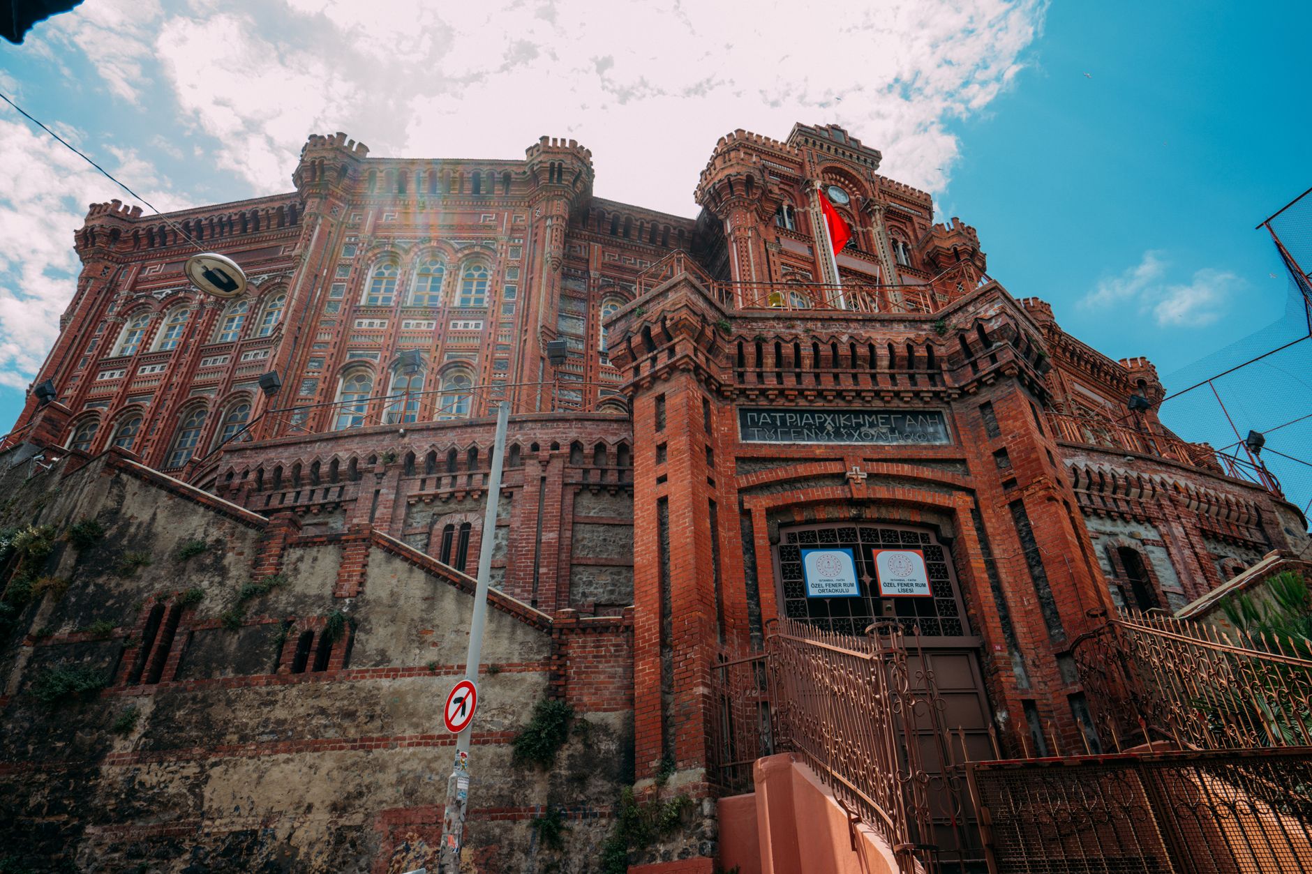 Low angle shot of the iconic Phanar Greek Orthodox College in Istanbul showcasing red brick architecture.