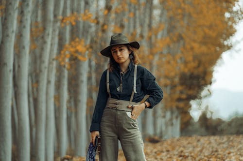 A Woman in Black Long Sleeves Wearing a Hat while Looking with a Serious Face