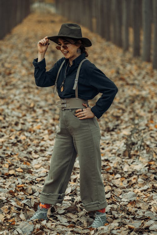 Woman Posing on a Footpath Covered in Fallen Autumn Leaves