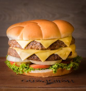A mouthwatering double cheeseburger with fresh ingredients on a wooden board.