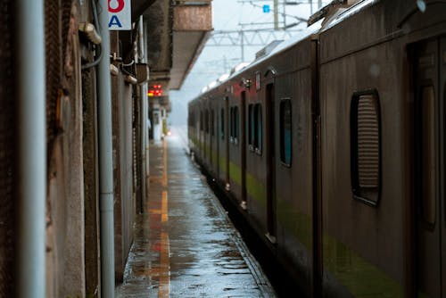 Бесплатное стоковое фото с железнодорожная платформа, железнодорожная станция, мокрый