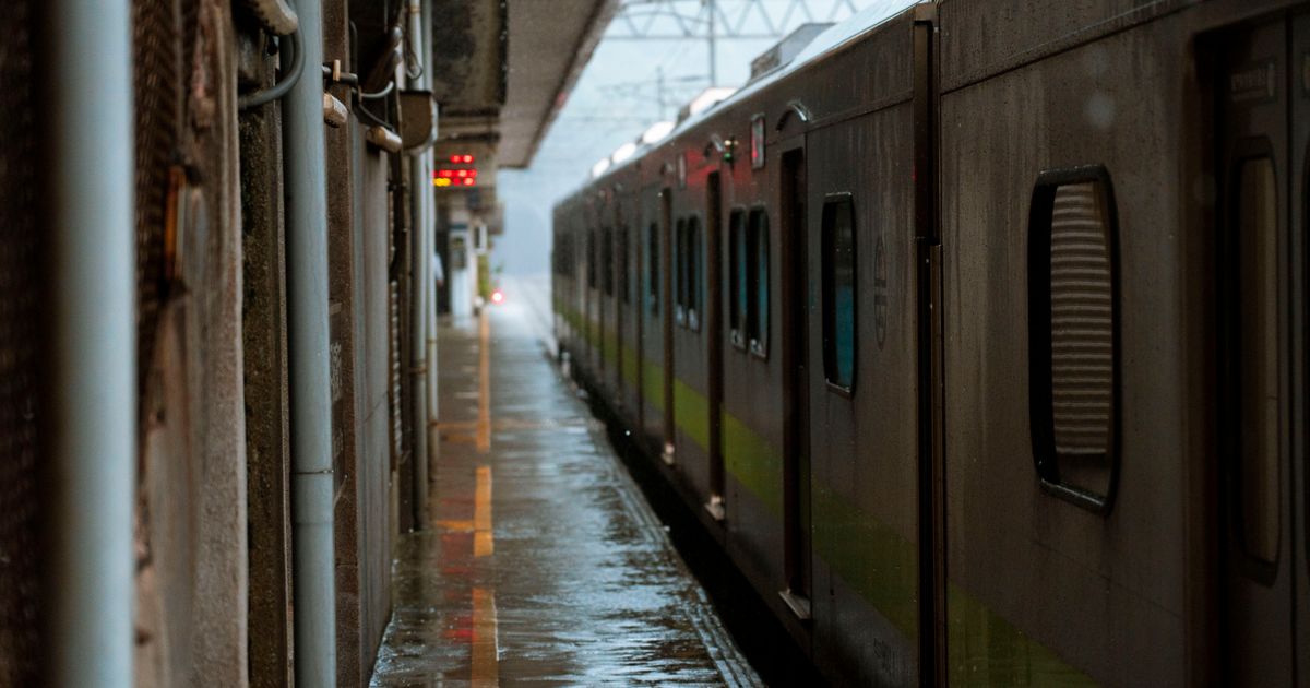 雨の日のホームと停車中の電車のイメージ写真