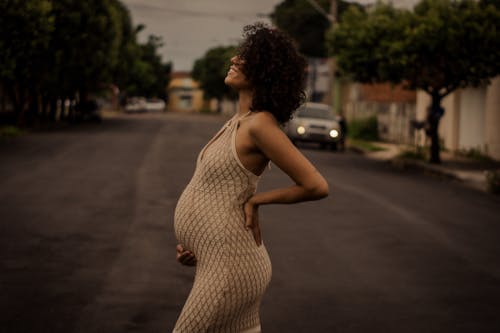 Pregnant Woman in Beige Sleeveless Dress Crossing the Street