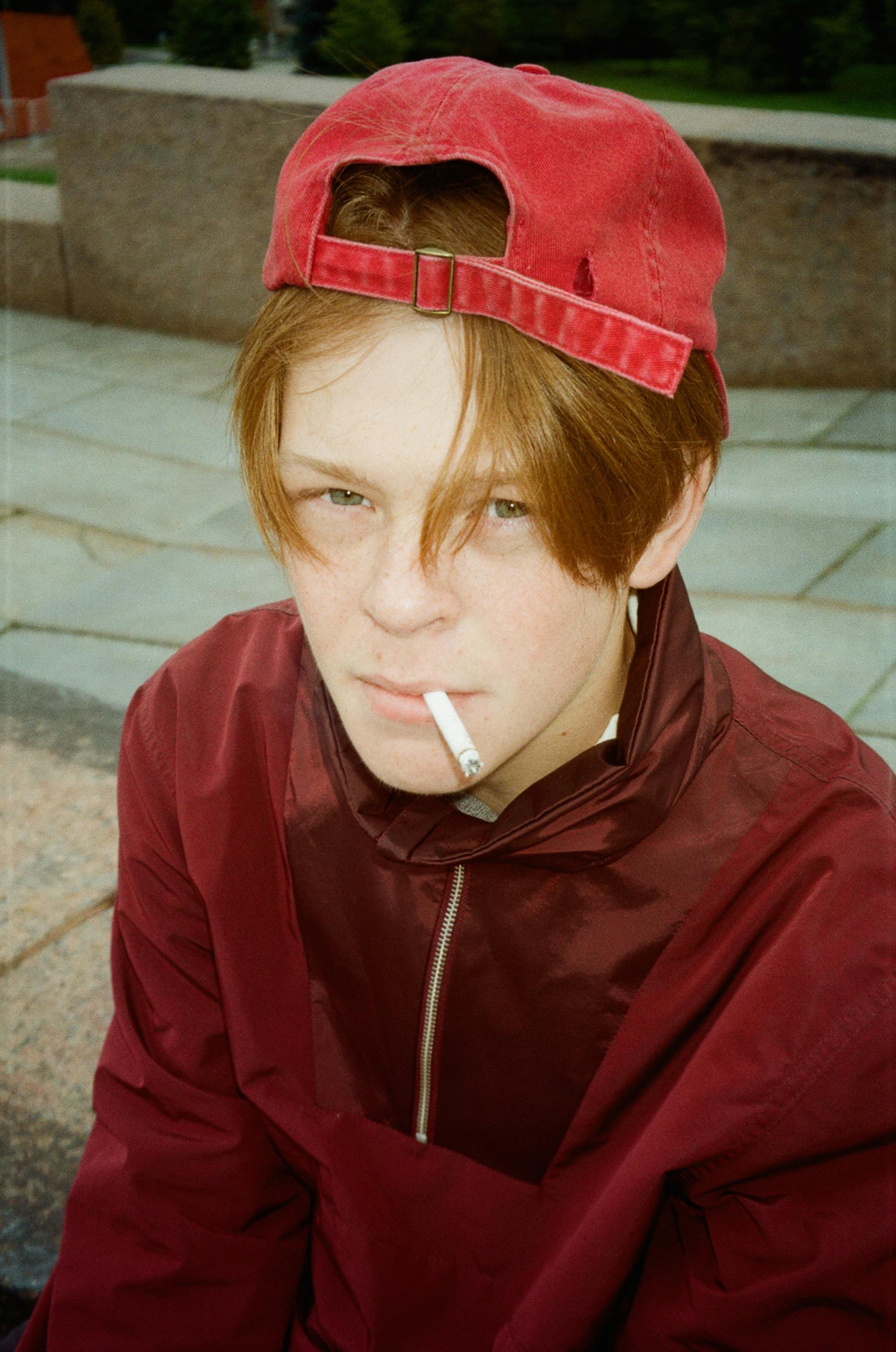 Young Man Smoking a Cigarette and Holding a Baseball Bat · Free Stock Photo