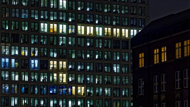 Illuminated office building facade with glowing windows at night.