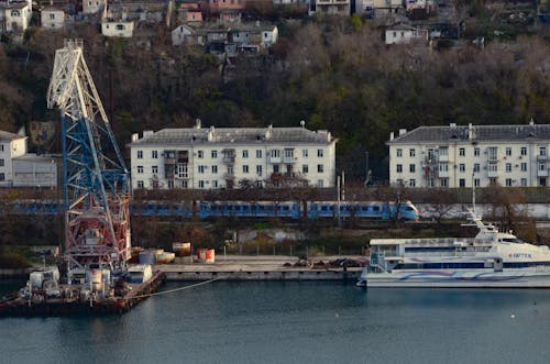 Train Riding along the Shore near a Harbor 