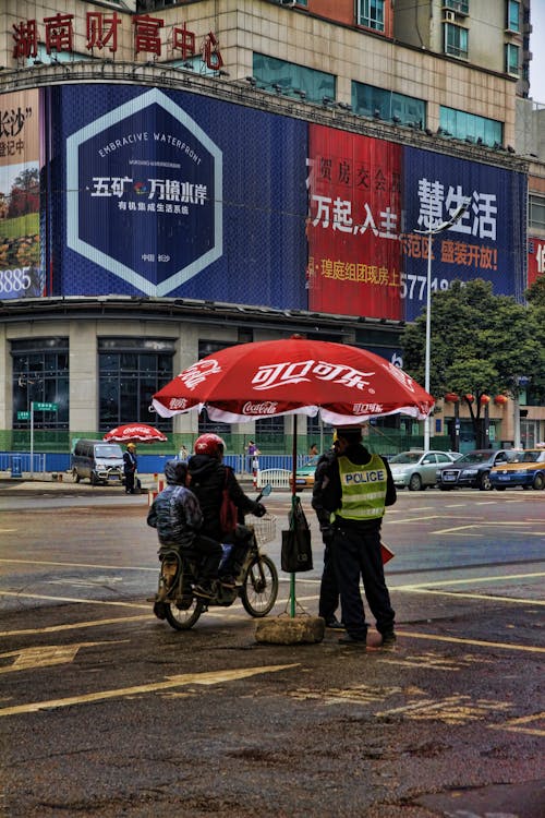 Policemen Standing Under Red Umbrella