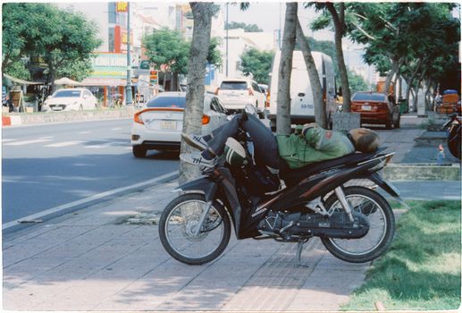 Person Lying on a Parked Motorcycle 