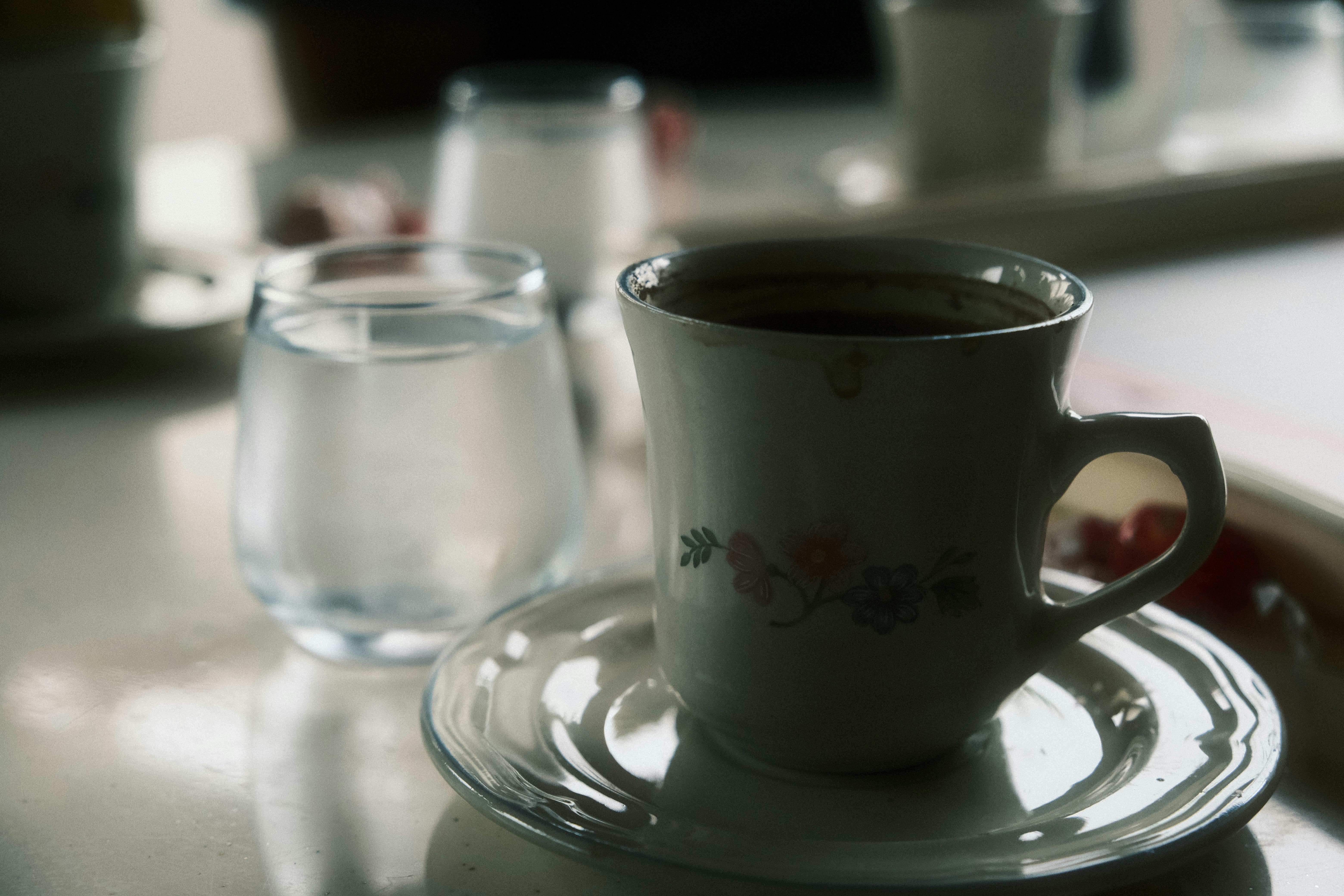 A cup of coffee next to a pair of glasses photo – Free Italy Image