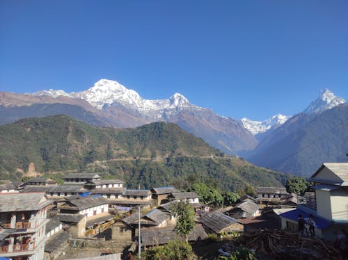 A Small Town Near Green Hills Under Blue Sky