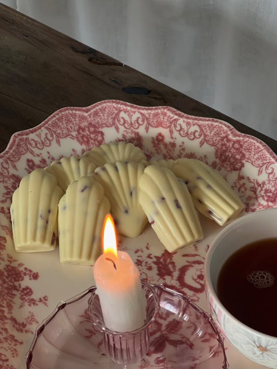 Free Still Life with White Chocolates and a Candle on a Vintage Plate Stock Photo