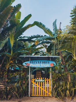 Tropical gateway welcoming visitors to Puerto Viejo, Costa Rica, framed by lush banana plants.