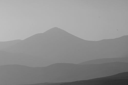 Minimalist view of Lanzarote's black and white mountain landscape. Ideal for nature and travel themes.