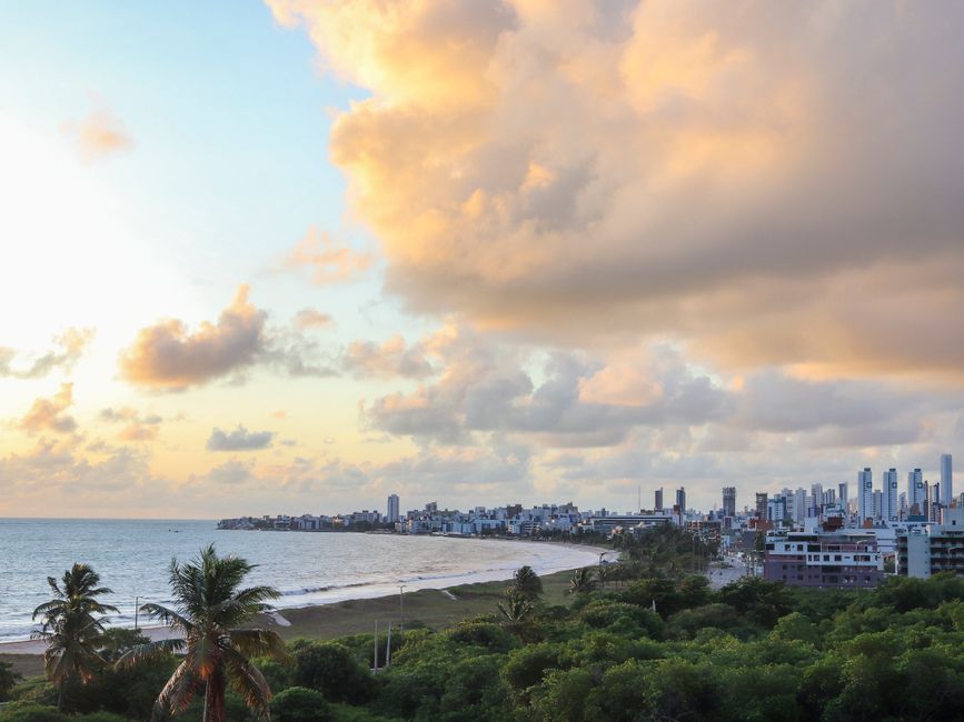 Capture of João Pessoa's coastline and skyline with dramatic sunset clouds.