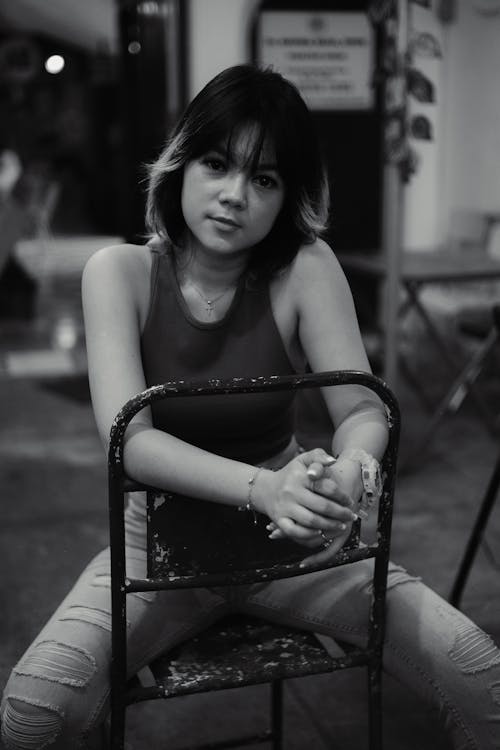 Black and White Photo of Woman Sitting on a Chair