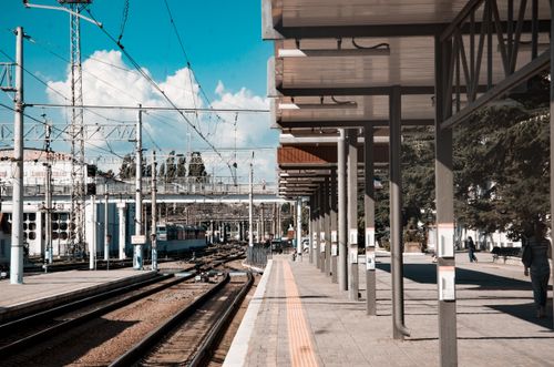 Free Urban train station under a clear blue sky, showcasing tracks and covered platforms. Stock Photo