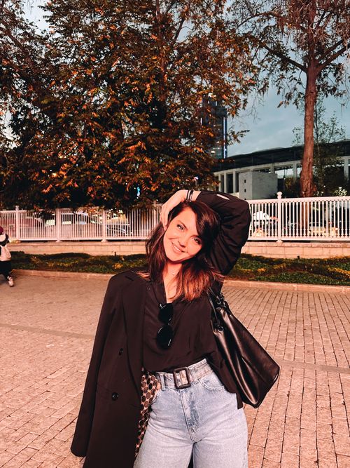 Free Chic young woman posing outside with a leather handbag in autumn setting. Stock Photo