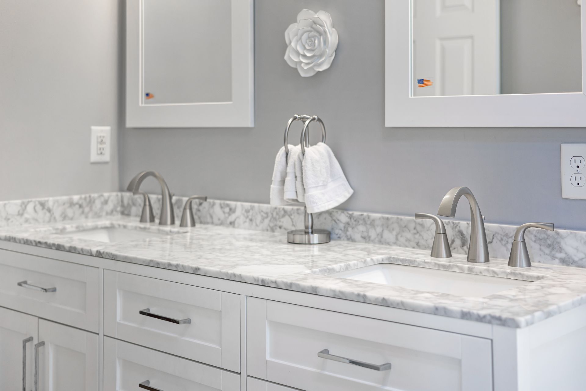 Elegant gray and white bathroom with marble countertop and dual sinks, highlighting interior design.