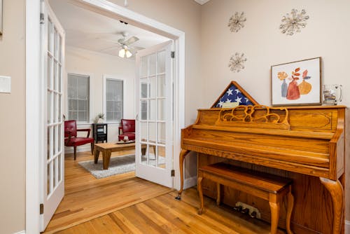 Brown Wooden Piano beside White Wooden Door