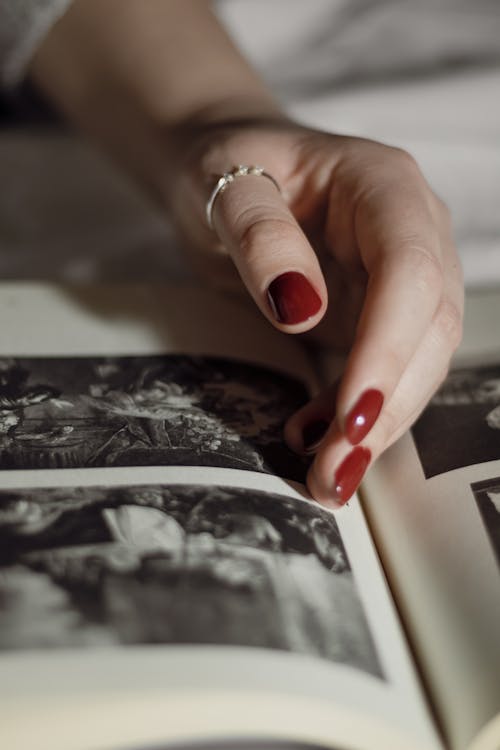 Woman Hand over Pictures in Book