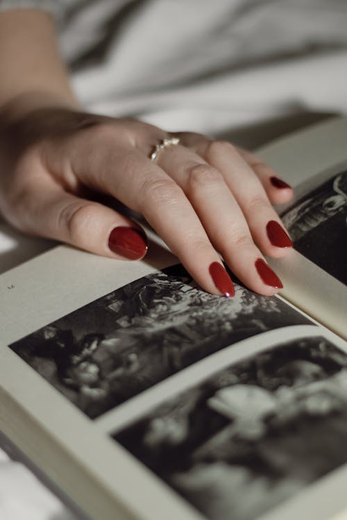 Woman Hand on Page with Pictures