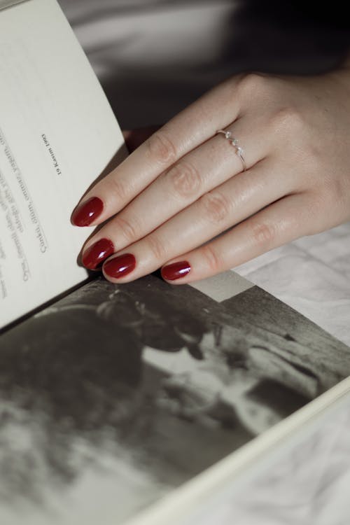 Woman Hand Holding Book Page with Vintage Picture