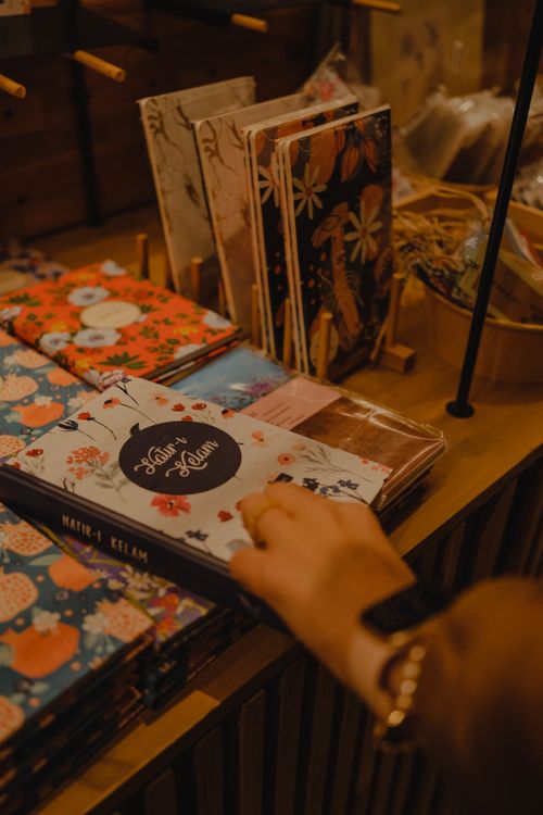 Notebook In Store Woman Choosing Floral Patterned Notebooks in a Store · Free Stock Photo