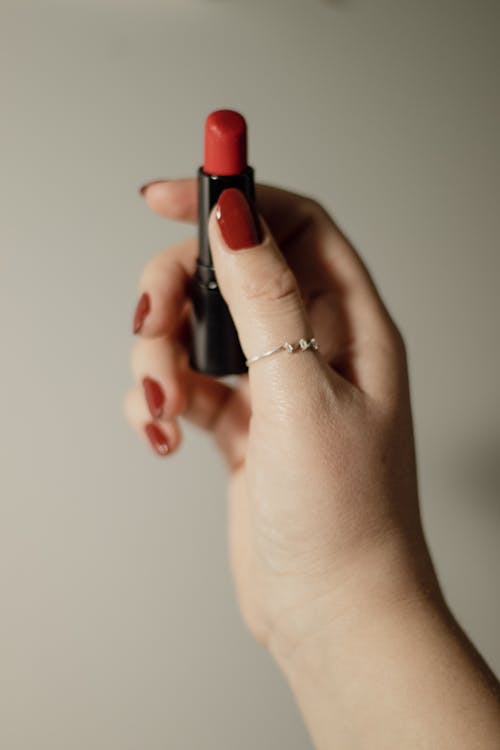 Close-up of Woman with Red Nails Holding a Red Lipstick 