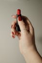 Close-up of Woman with Red Nails Holding a Red Lipstick