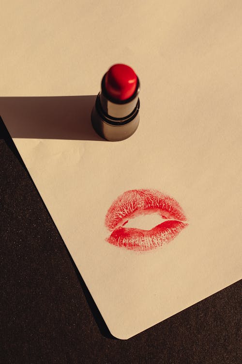 A Red Lipstick and a Print of a Kiss on Paper 