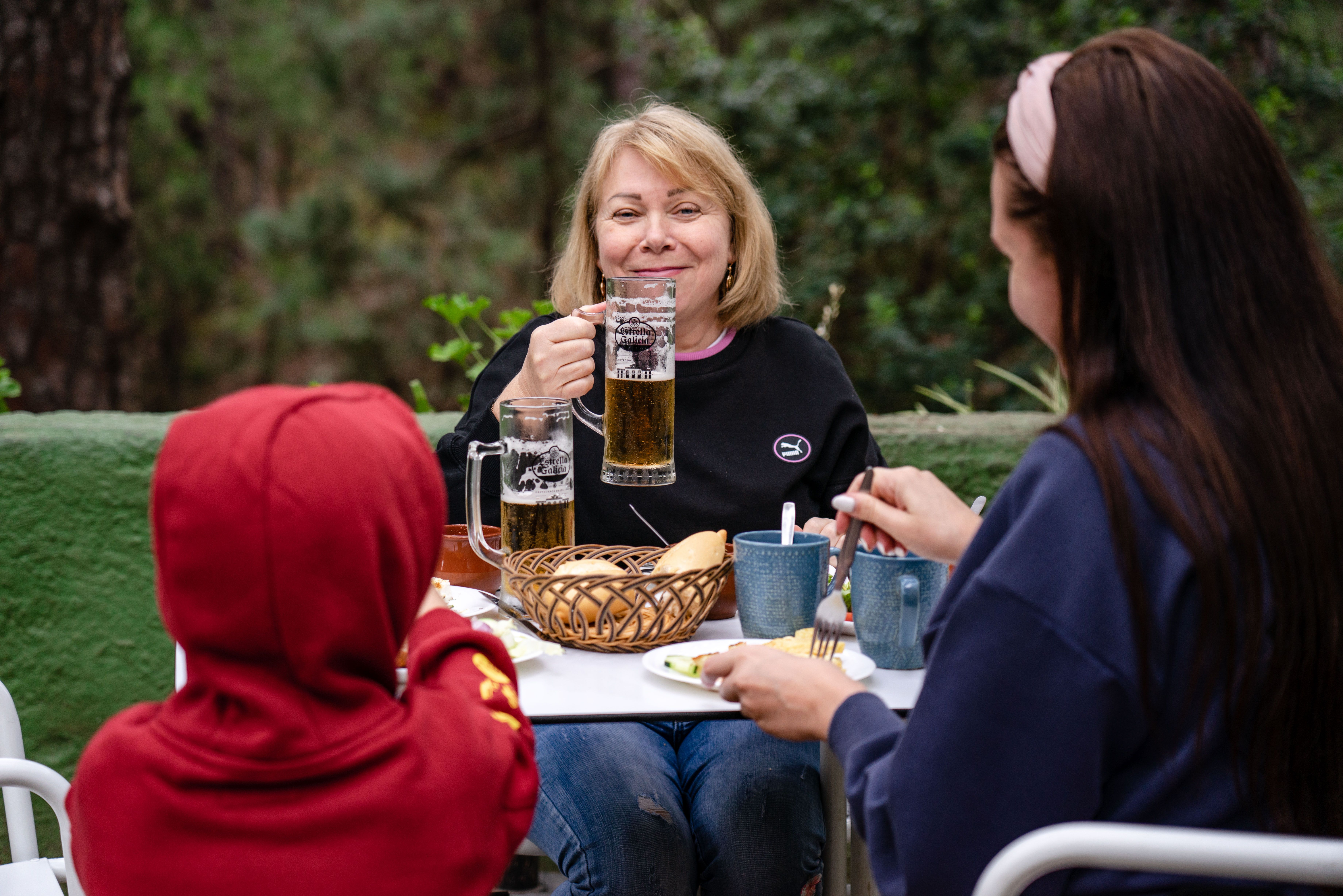 ビールやソフトドリンクを囲んで屋外で食事を楽しむ家族
