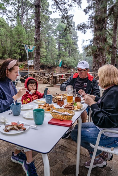 Family eating at a picnic table in the forest