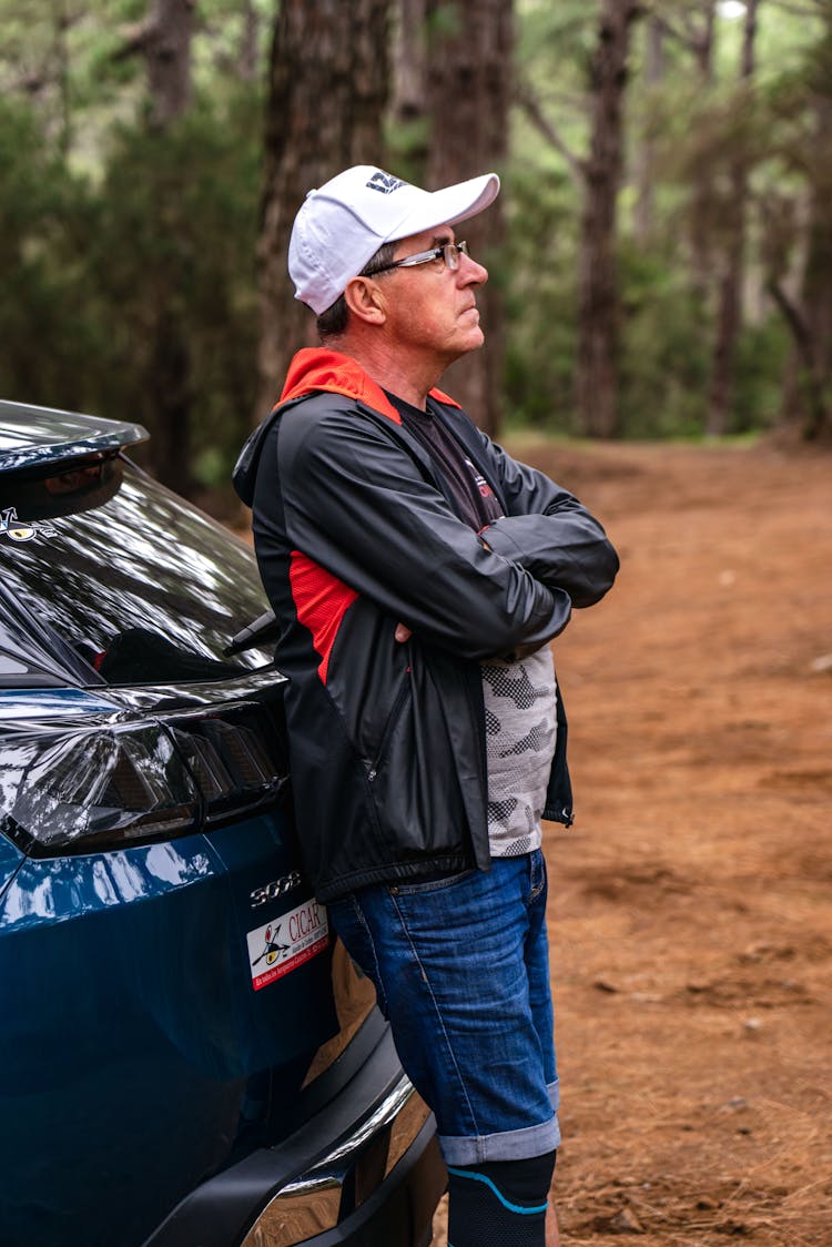 A Man Wearing Jacket Leaning On A Car