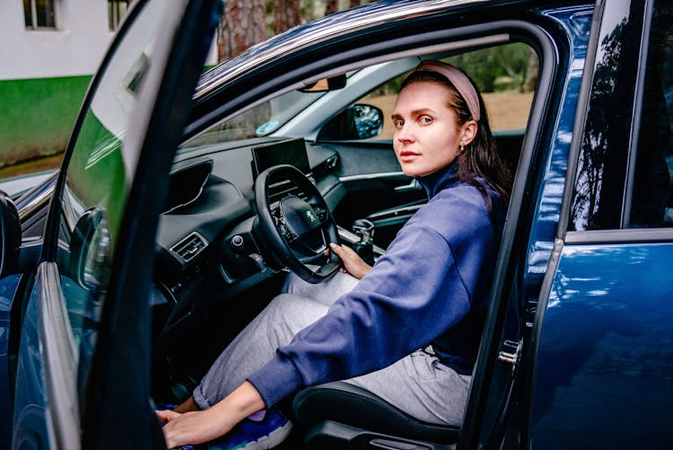 Photo Of A Woman Sitting In A Blue Car