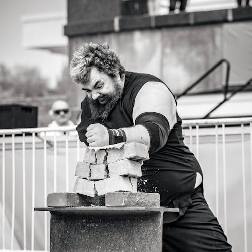 A Man Smashing Bricks on the Table