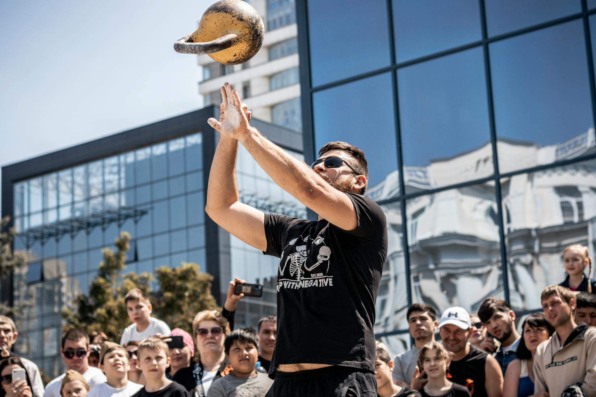 Man Throwing Steel Weight in Air