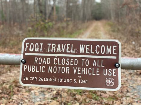 Metal Sign Screwed to Barrier in Forest