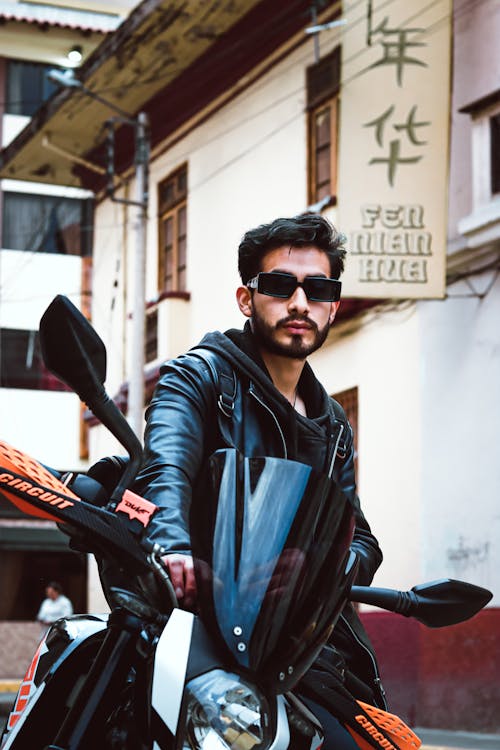 A Bearded Man in a Leather Jacket Sitting on a Motorcycle