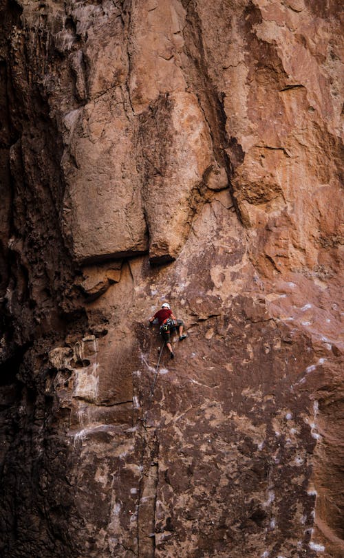 View of a Man Climbing a Rocky Cliff 