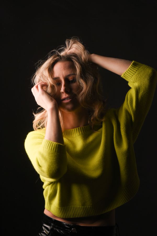 Woman wearing a metallic green sweater with black pants