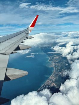 Breathtaking view of coastline and clouds from an airplane window. Perfect for travel enthusiasts.