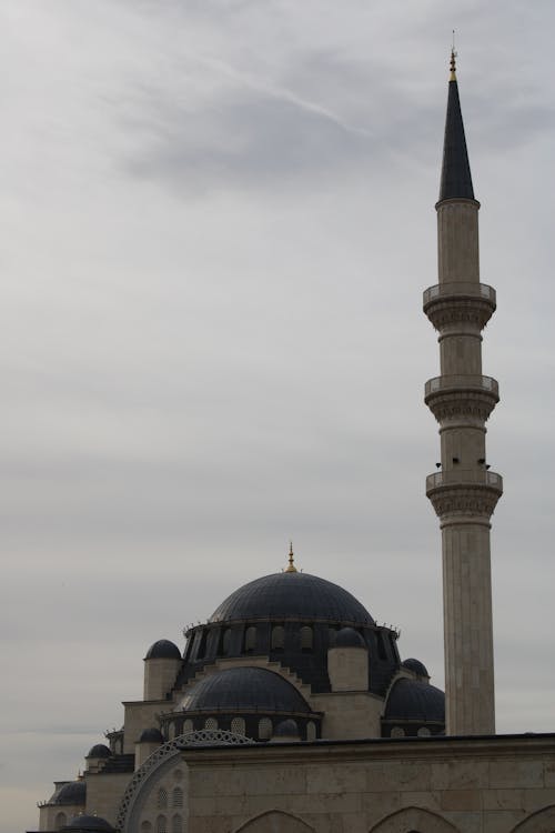 View of a Dome and Minaret of a Mosque under a Cloudy Sky 