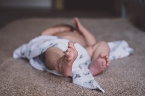 Free Baby Lying on Brown Surface Stock Photo