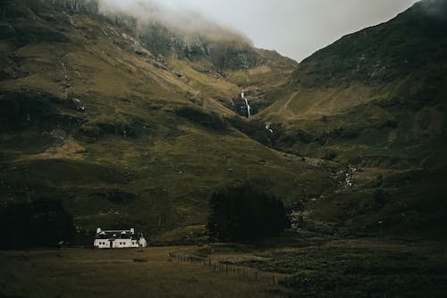 View of a White House in a Dark Valley under a Cloudy Sky 